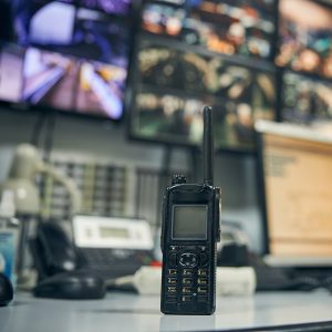 Close-up photo of a walkie-talkie sitting on an office desk in a security control room